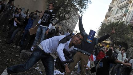 Des manifestants jettent des pierres sur les forces de police, au Caire (Egypte), le 21 novembre 2011. (MOHAMMED HOSSAM / AFP)