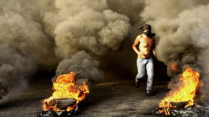 Un manifestant libanais bloque une route dans la ville de Sidon, dans le sud du pays, samedi 20 octobre 2012.&nbsp; (MAHMOUD ZAYYAT / AFP)