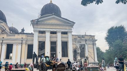 Des personnes nettoient les débris autour de la cathédrale de la Transfiguration, en partie détruite, après des frappes russes sur Odessa (Ukraine), le 23 juillet 2023. (ANADOLU AGENCY / AFP)