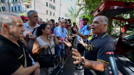 Les riverains, évacuées d'urgence mardi 14 août après l'effondrement d'un viaduc à Gênes en Italie, parlementent avec les autorités pour tenter de récupérer leurs biens. (ANDREA LEONI / AFP)