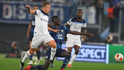 Duel acharné entre le Romain Lucas Leiva et le Marseillais Pepe Gueye, le 21 octobre 2021 à Rome au cours d'un match où il existe&nbsp;une présomption de cris&nbsp;racistes proférés par certains membres du public à l'encontre de joueurs de l'OM. (CLAUDIO PASQUAZI / ANADOLU AGENCY / AFP)