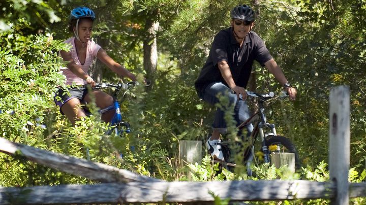 Barack Obama et sa fille Malia font du v&eacute;lo &agrave; West Tibury (Massachusetts), le 23 ao&ucirc;t 2011. (JIM WATSON / AFP)