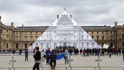 La pyramide du Louvre disparaît sous le collage de JR (24 mai 2016)
 (photo Valérie Oddos / Culturebox / France Télévisions)