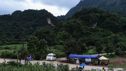 Une ambulance quitte la grotte de Tham Luang, au nord de la Thaïlande, le 10 juillet 2018. Douze enfants et leur entraîneur de foot sont restés coincés dans la cavité durant 18 jours, à cause de&nbsp;la montée des eaux. (YE AUNG THU / AFP)