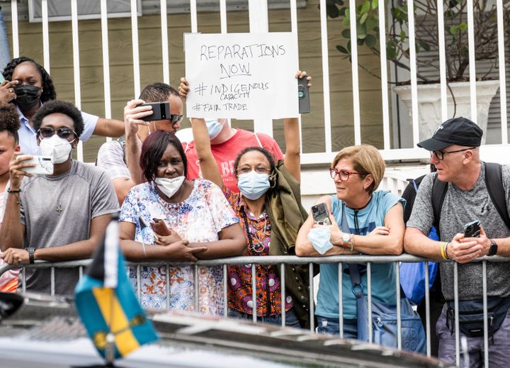 Une femme porte une pancarte demandant des réparations de la part de la monarchie britannique pour son passé colonial, à Nassau, aux Bahamas, le 25 mars 2022. (POOL/SAMIR HUSSEIN / WIREIMAGE / GETTY IMAGES)