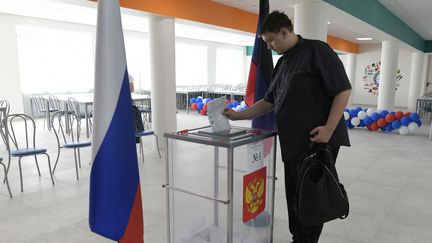 Un homme dépose son bulletin dans une urne lors d'élections locales organisées par la Russie, le 8 septembre 2023 à Donetsk (Ukraine). (AFP)