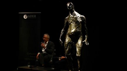 Un commissaire-priseur lors de la présentation d'œuvres d'art appartenant à Gérard Depardieu, dont la statue en bronze "L'homme qui marche" de Germaine Richier à la maison de ventes Drouot à Paris, le 15 juin 2023. (CHRISTOPHE ARCHAMBAULT / AFP)