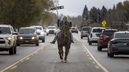 A Driggs, petite ville de l'Idaho, Vancie Turner a chevauché sa jument Clémentine, mardi 5 novembre, pour lancer dans la rue un ultime appel à la mobilisation dans les urnes. (NATALIE BEHRING / GETTY IMAGES)