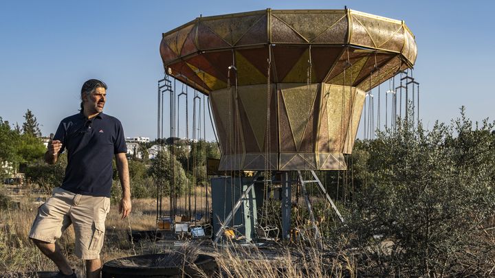 Christos Zoumides connait bien l'ancien parc d'attraction de Tivoli, à Nicosie, où il se rendait plus jeune avec sa famillez. Ici, le chercheur et fan d'urbex devant un manège abandonné, en 2023. (AMIR MAKAR / AFP)