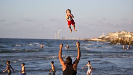 Un Palestinien joue avec son b&eacute;b&eacute; sur une plage &agrave; Gaza (Palestine), le 7 septembre 2014. (MAHMUD HAMS / AFP)