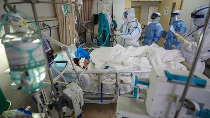 Des médecins chinois au chevet d'un patient atteint du coronavirus, le 6 mars 2020 à Wuhan (Chine). (AFP)