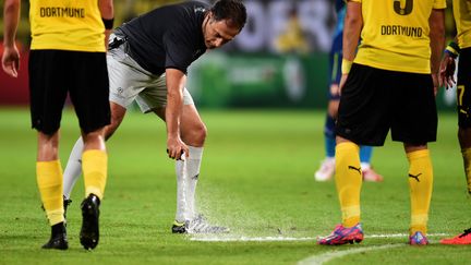 L'arbitre&nbsp;Olegario Benquerenca tra&ccedil;ant une ligne avec le spray,&nbsp;lors du match de Ligue des champions&nbsp;Borussia Dortmund-Arsenal, le 16 septembre.&nbsp; (PATRIK STOLLARZ / AFP)