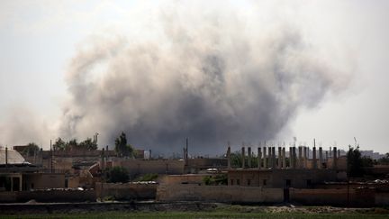 De la fumée s'élève au-dessus de Raqqa (Syrie) après un raid de la coalition internationale contre le groupe Etat islamique, le 21 juin 2017. (DELIL SOULEIMAN / AFP)