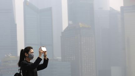 Une femme prend une photo&nbsp;dans la ville de&nbsp;Shanghai (Chine) polluée, le 7 mars 2016.&nbsp; (ALY SONG / REUTERS)