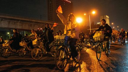 Des étudiants à vélo sur la route entre Zhengzhou et Kaifeng, dans la province du Henan, au nord de la Chine, le 9 novembre 2024. (STRINGER / AFP)