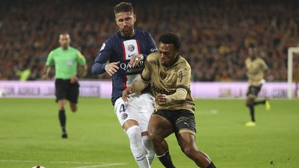 Sergio Ramos au duel avec Loïs Openda lors de Lens-PSG, le 1er janvier 2023. (JEAN CATUFFE / AFP)