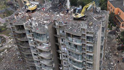 Des pelleteuses d&eacute;molissent un immeuble r&eacute;cemment construit apr&egrave;s avoir d&eacute;couvert que celui-ci penchait, Zhejiang (Chine), le 6 d&eacute;cembre 2011. (CHINA DAILY / REUTERS)