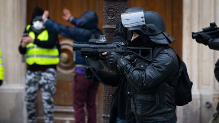 Un policier fait usage de son LDB, lors d'une manifestation parisienne des "gilets jaunes". (ALEXIS SCIARD  / MAXPPP)