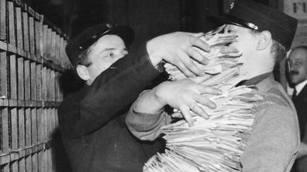 Le facteur et ses piles de lettres. C'était à Paris en 1935. 18 milliards de lettres envoyées en 2008 et aujourd'hui la moitité, soit 9 milliards...&nbsp; (GETTY IMAGES)