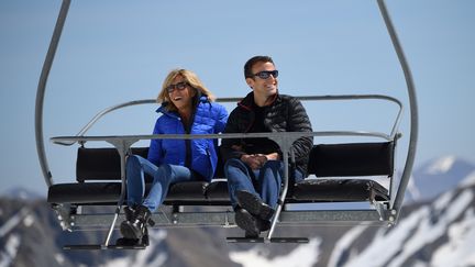 Emmanuel Macron, alors candidat à l'élection présidentielle, et son épouse Brigitte sur un télésiège lors d'une visite dans la station de ski de La Mongie (Hautes-Pyrénées), le 12 avril 2017. (ERIC FEFERBERG / AFP)