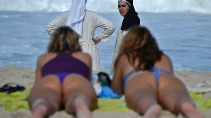 Deux religieuses se m&egrave;lent aux touristes sur la plage de Copacabana &agrave; Rio de Janeiro (Br&eacute;sil), le 27 juillet 2013. (VANDERLEI ALMEIDA / AFP)