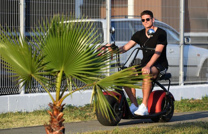 Le joueur allemand Mario Gomez arrive en scooter à l'hôtel où est rassemblée son équipe à Sotchi (Russie), le 21 juin. (INA FASSBENDER / DPA / AFP)