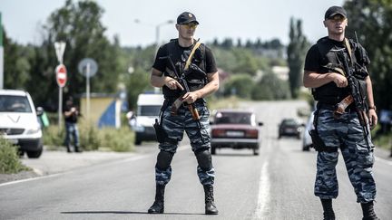 Des miliciens pro-russes bloquent la route, le 28 juillet 2014,&nbsp;aux enqu&ecirc;teurs n&eacute;&eacute;rlandais et australiens, dans la r&eacute;gion de Donetsk, o&ugrave; s'est &eacute;cras&eacute;&nbsp;un avion de Malaysia Airlines. (BULENT KILIC / AFP)