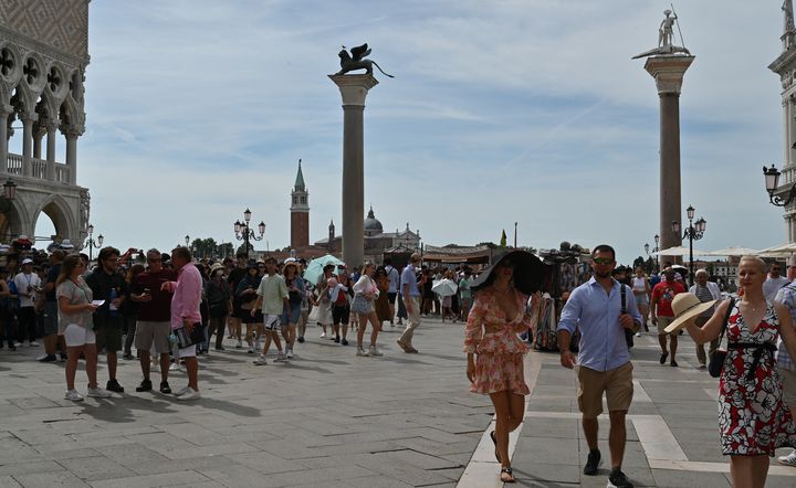 Des touristes traversant la place Saint-Marc à Venise le 31 juillet 2023. L'Unesco recommande que Venise soit inscrite sur la liste du patrimoine mondial en péril. (ANDREA PATTARO / AFP)