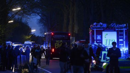 Les pompiers interviennent pour aider les joueurs du Borussia Dortmund après une triple explosion aux abords de leur bus, le 11 avril 2017. (SASCHA SCHUERMANN / AFP)