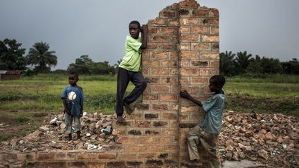 Le 26 octobre 2017, de jeunes Congolais jouent près d'un bâtiment détruit à Kasala, dans la région agitée du Kasaï, dans le centre de la République démocratique du Congo. (JOHN WESSELS / AFP )