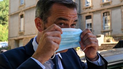 Olivier Véran enfile un masque, le 21 août 2020, lors d'un déplacement à Florac (Lozère). (PASCAL GUYOT / AFP)