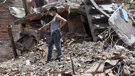 Un habitant n&eacute;palais n&eacute;toie les d&eacute;bris de sa maison &agrave; Katmandou le 27 avril 2015. (PRAKASH SINGH / AFP)