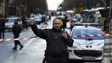 Un policier dévie les voitures au niveau du boulevard Barbès à Paris, le 7 janvier 2016. (LIONEL BONAVENTURE / AFP)