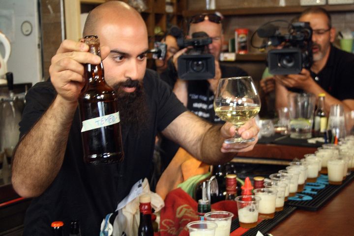 Shmuel Nakai, propriétaire du Biratenu Bar, savoure un hydromel et une bière issus de levures vieilles de plusieurs milliers d'années, mercredi 22 mai 2019 à Jérusalem (Israël). (ROBERT MESSER / DPA / AFP)