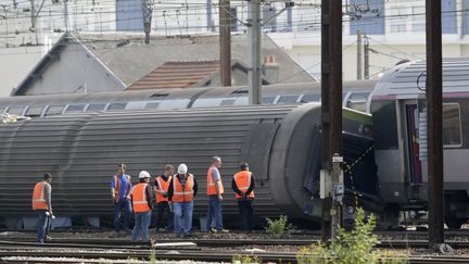 Des enqu&ecirc;teurs inspectent le train accident&eacute; de Br&eacute;tigny-sur-Orge (Essonne), le 13 juillet 2013. (KENZO TRIBOUILLARD / AFP)