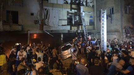 Des équipes de pompiers&nbsp;interviennent à l'extérieur d'un bâtiment après l'explosion d'un réservoir de mazout dans un quartier résidentiel de Beyrouth (Liban), le 9 octobre 2020. (HOUSSAM SHBARO / ANADOLU AGENCY / AFP)