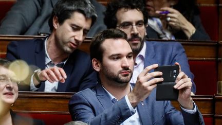 Ugo Bernalicis (avec le portable) dans l'hémicycle de l'Assemblée nationale le 5 février 2019 (THOMAS PADILLA / MAXPPP)