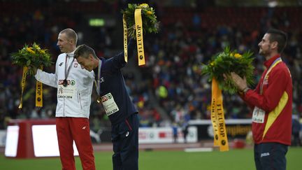 Yoann Kowal et le Polonais&nbsp;Krystian Zalewski posent pour la photo du podium du 3 000 m steeple laissant seul l'Espagnol Angel Mullera. (FABRICE COFFRINI / AFP)