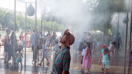 Des vacanciers se rafraichissent au premier jour de l'op&eacute;ration "Paris Plages", samedi 20 juillet 2013 &agrave; Paris. (FRED DUFOUR / AFP)