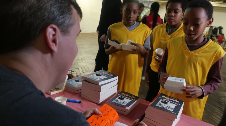 L'écrivain pour la jeunesse Jeff Kinney dédicace son livre "Journal d'un dégonflé - Ca déménage", (Seuil Jeunesse), le 10 décembre 2019 (Laurence Houot / franceinfo Culture)