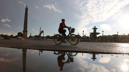 Une cycliste circule place de la Concorde le 22 juin 2015 &agrave; Paris. (LUDOVIC MARIN / AFP)