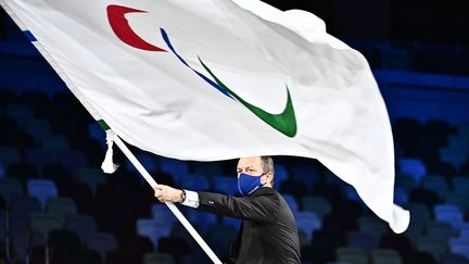 Le président du Comité international paralympique Andrew Parsons agite le drapeau à la cérémonie de clôture des Jeux de Pékin, le 5 septembre 2021. (PHILIP FONG / AFP)