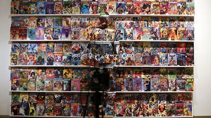 L'artiste chinois Liu Bolin pose devant un arri&egrave;re-plan rempli de "comics" lors d'une performance &agrave; Caracas (Venezuela), le 2 novembre 2013. (JORGE SILVA / REUTERS)