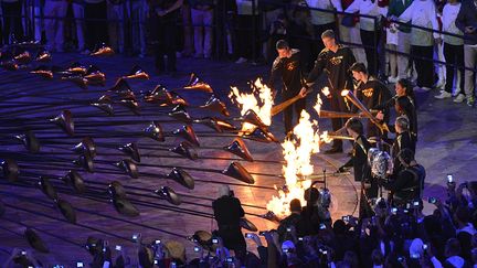 Pas de star pour enflammer Londres. Sept jeunes sportifs ont allum&eacute; ensemble la flamme olympique. (SAEED KHAN / AFP)