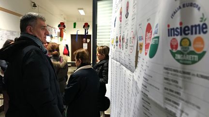 Un homme regarde les listes de vote dans un bureau électoral à Rome (Italie), le 4 mars 2018. (MAX ROSSI / REUTERS)