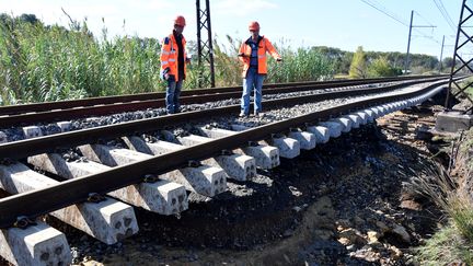 Des techniciens de la SNCF sur la voie de chemin de fer endommagée à&nbsp;Villeneuve-les-Beziers (Hérault), le 24 octobre 2019. (PASCAL GUYOT / AFP)