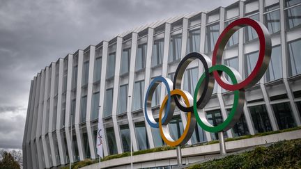 Les anneaux olympiques exposés devant le siège du Comité international Olympique à Lausanne (Suisse), le 25 mars 2023. (FABRICE COFFRINI / AFP)