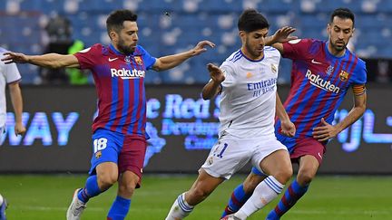 Marco Asensio à la lutte avec Jordi Alba et Sergio Busquets lors de la demi-finale de Supercoupe d'Espagne, le 12 janvier 2022. (- / AFP)