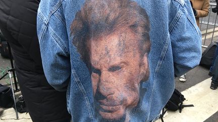 Un fan de Johnny Hallyday montre son blouson à l'effigie du chanteur, le&nbsp;6 décembre 2017, devant le domicile du chanteur à Marnes-la-Coquette (Hauts-de-Seine). (FARIDA NOUAR / RADIO FRANCE)