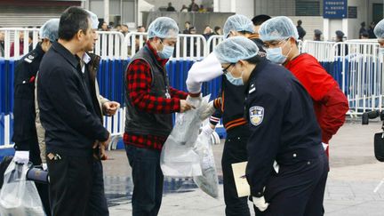 Des policiers chinois pr&eacute;l&egrave;vent des indices &agrave; la gare de Canton (Chine), o&ugrave; neuf personnes ont &eacute;t&eacute; bless&eacute;es par un homme arm&eacute; d'un couteau, le 6 mars 2015. (IMAGINECHINA / AFP)